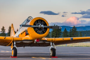 SNJ-5 parked on the ramp with the sun setting behind it